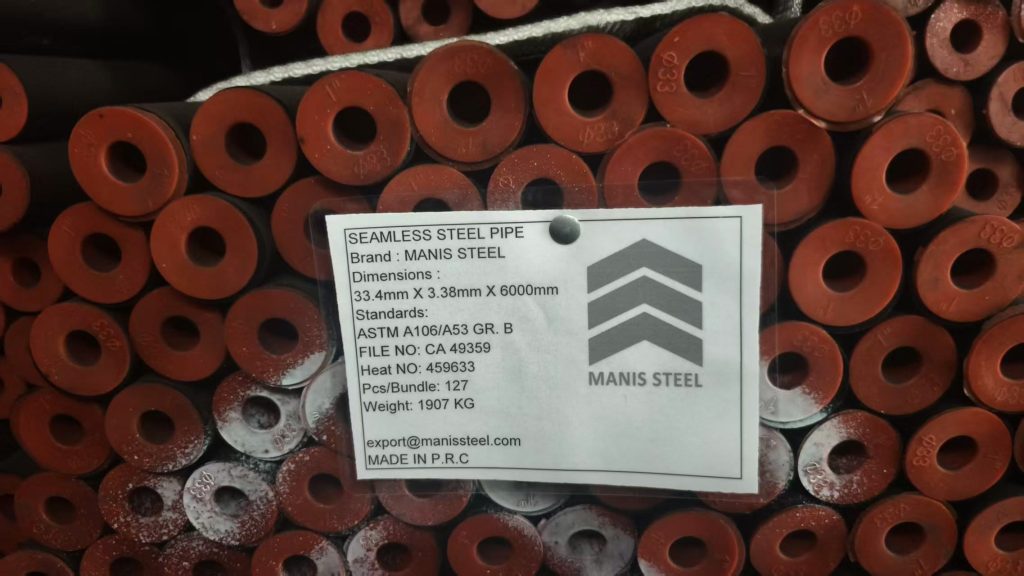 برچسب واضح MANIS STEEL با ابعاد 33.4mm، استاندارد ASTM A106/A53 و نشان کامل شرکت