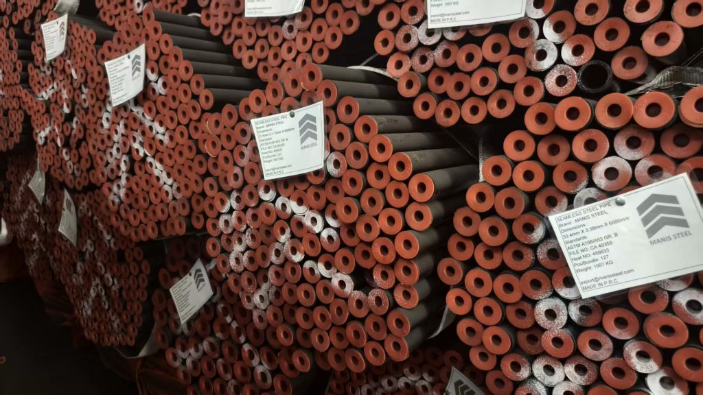 دیوار بسته‌های لوله با برچسب‌های تکرارشونده MANIS STEEL از همان محموله